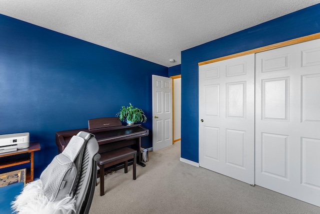 carpeted office space with baseboards and a textured ceiling