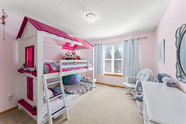 bedroom featuring visible vents, carpet floors, a textured ceiling, and baseboards