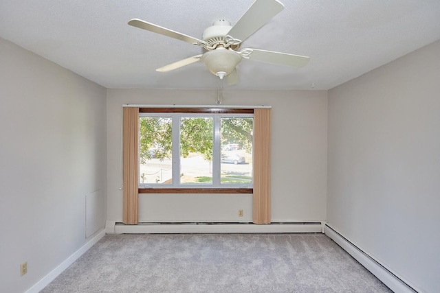 spare room featuring baseboard heating, a ceiling fan, and light colored carpet