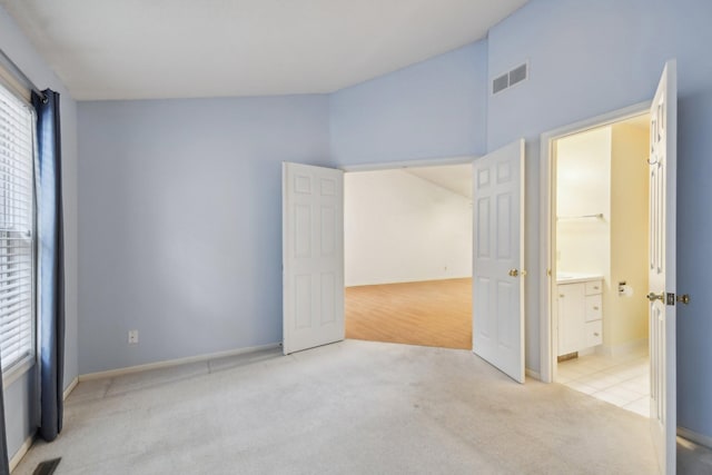 unfurnished room with light colored carpet, vaulted ceiling, and visible vents