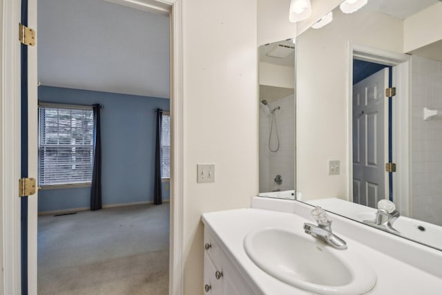 bathroom featuring a shower, vanity, and baseboards