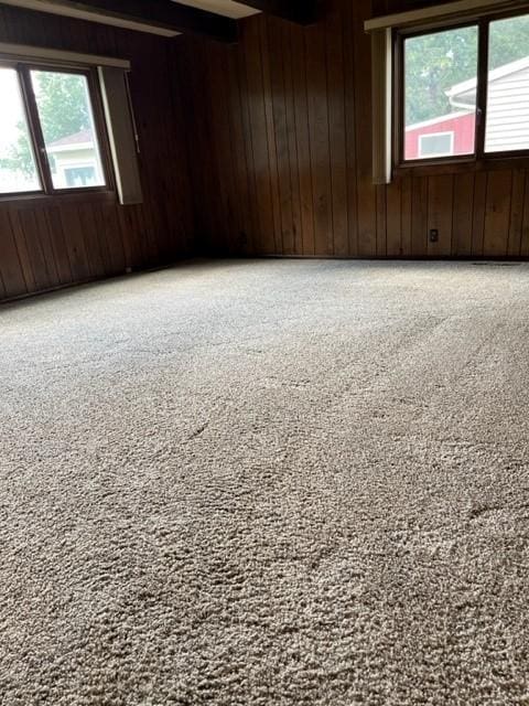 empty room with wooden walls and beam ceiling