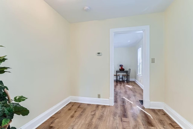 hallway with wood finished floors and baseboards