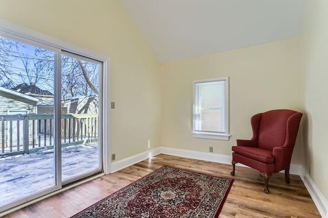 sitting room featuring baseboards, wood finished floors, and lofted ceiling