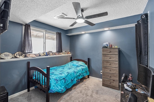 carpeted bedroom with a textured ceiling, baseboards, and a ceiling fan