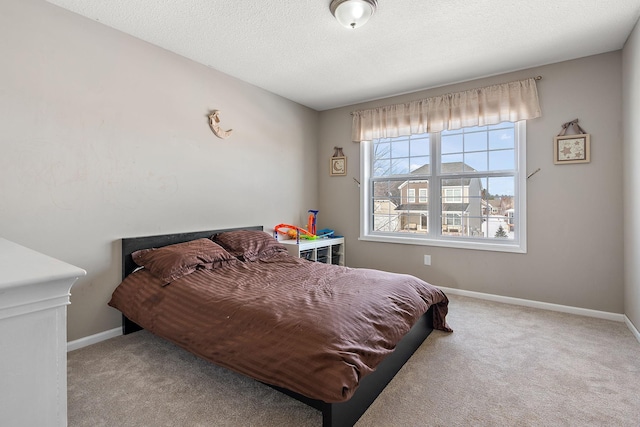 carpeted bedroom featuring a textured ceiling and baseboards