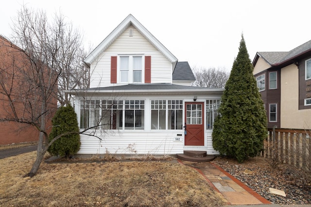 view of front of home with entry steps, roof with shingles, and fence