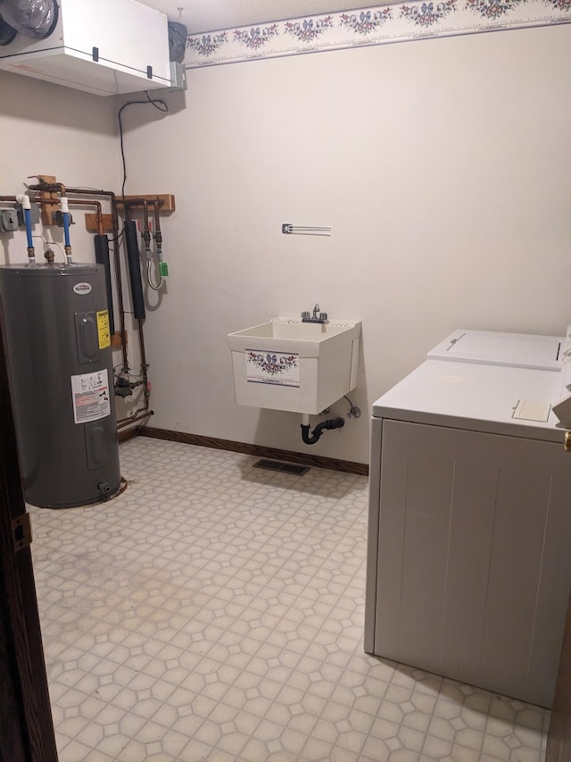 clothes washing area featuring a sink, light floors, water heater, and washer and dryer