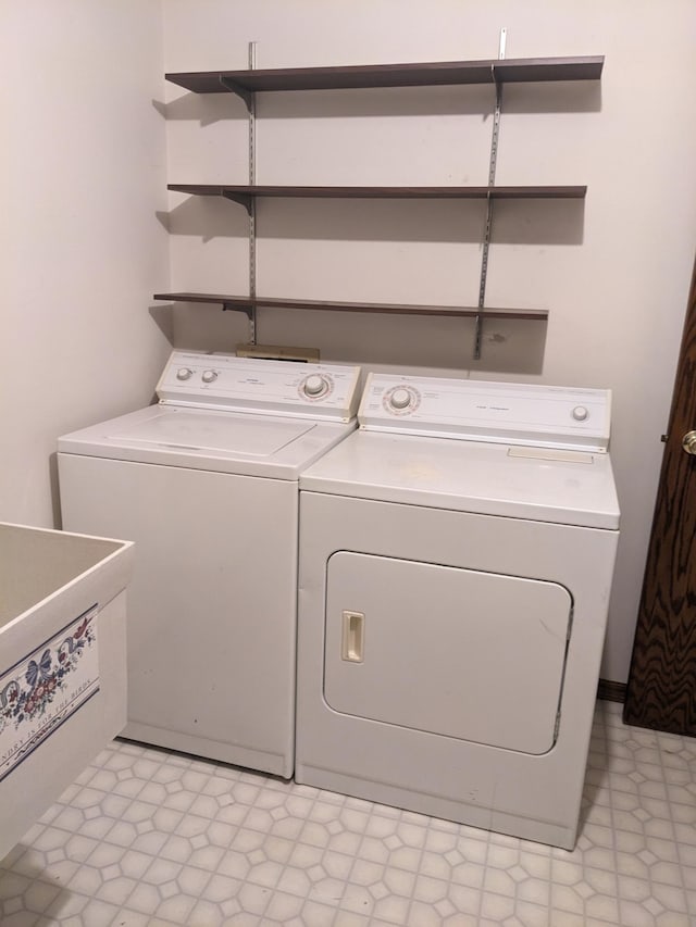 washroom featuring a sink, laundry area, washing machine and dryer, and light floors