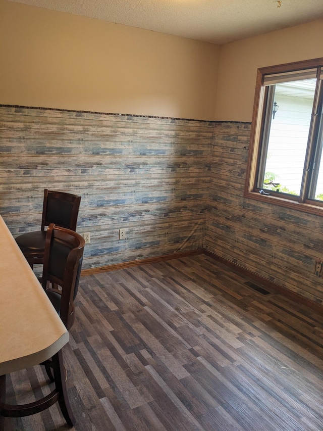 unfurnished office with dark wood finished floors and a textured ceiling