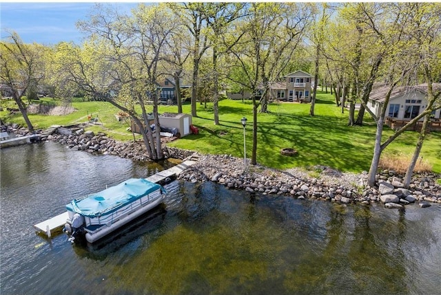 dock area with a lawn and a water view