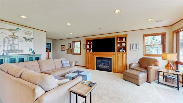 living room with crown molding, recessed lighting, a glass covered fireplace, and light colored carpet