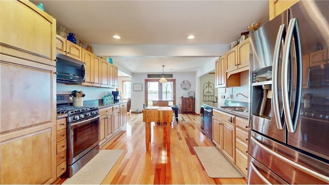 kitchen featuring recessed lighting, a sink, appliances with stainless steel finishes, light wood finished floors, and pendant lighting