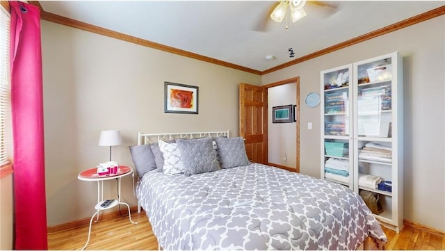 bedroom featuring ornamental molding, light wood finished floors, a ceiling fan, and baseboards