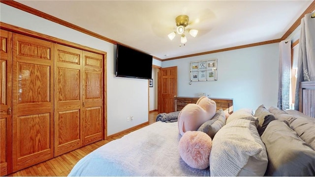 bedroom with ornamental molding, light wood-style flooring, and baseboards