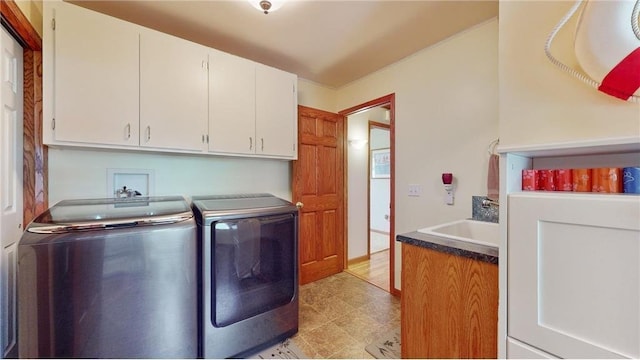 laundry room featuring cabinet space, independent washer and dryer, and a sink