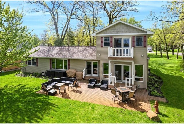 back of property featuring a yard, a patio, outdoor lounge area, and a balcony