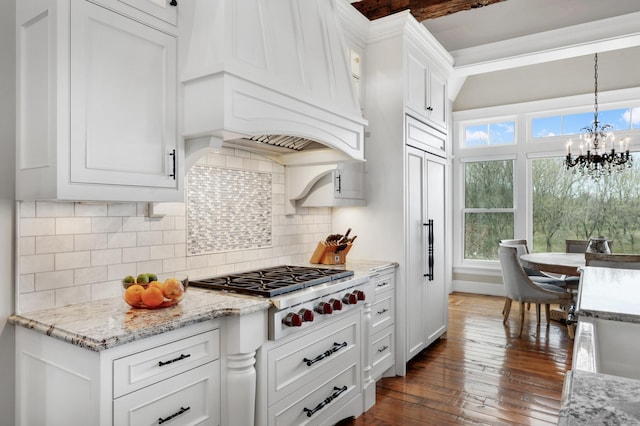 kitchen with stainless steel gas cooktop, dark wood-type flooring, light stone countertops, premium range hood, and white cabinetry