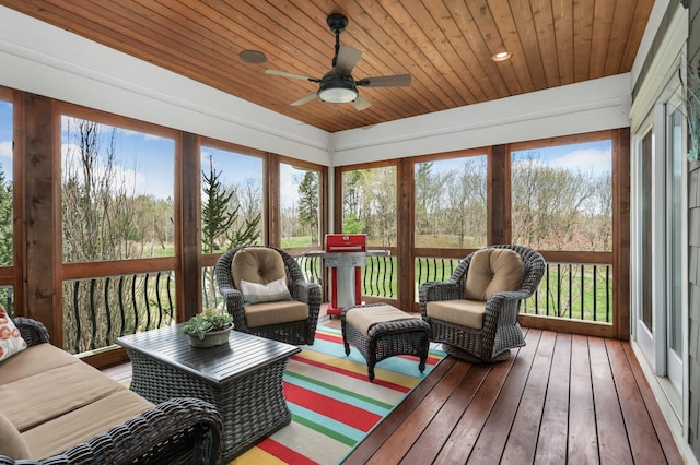 sunroom / solarium with a ceiling fan, wooden ceiling, and plenty of natural light