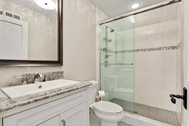 full bathroom featuring toilet, a stall shower, visible vents, and vanity