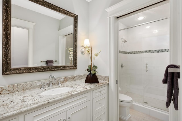 full bathroom featuring a shower stall, toilet, and vanity