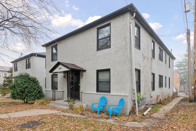 view of front facade featuring brick siding and stucco siding