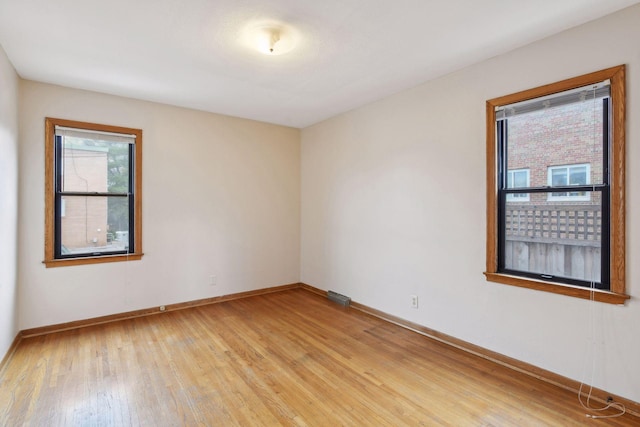 empty room with light wood-style flooring and baseboards