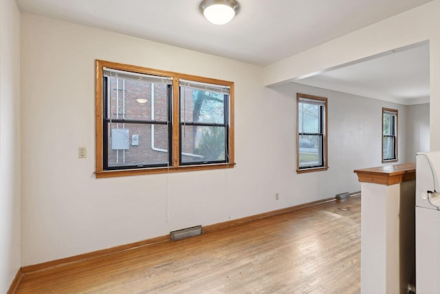 spare room with visible vents, light wood-style flooring, and baseboards