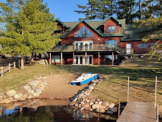 rear view of house featuring a deck, a yard, french doors, and fence