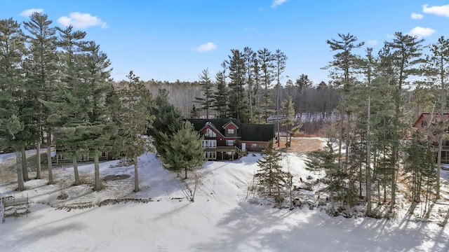 snowy aerial view featuring a forest view