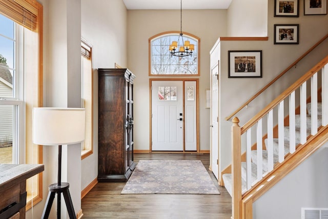 foyer featuring a healthy amount of sunlight, stairs, visible vents, and wood finished floors