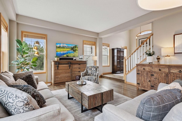 living room with baseboards, stairway, and wood finished floors