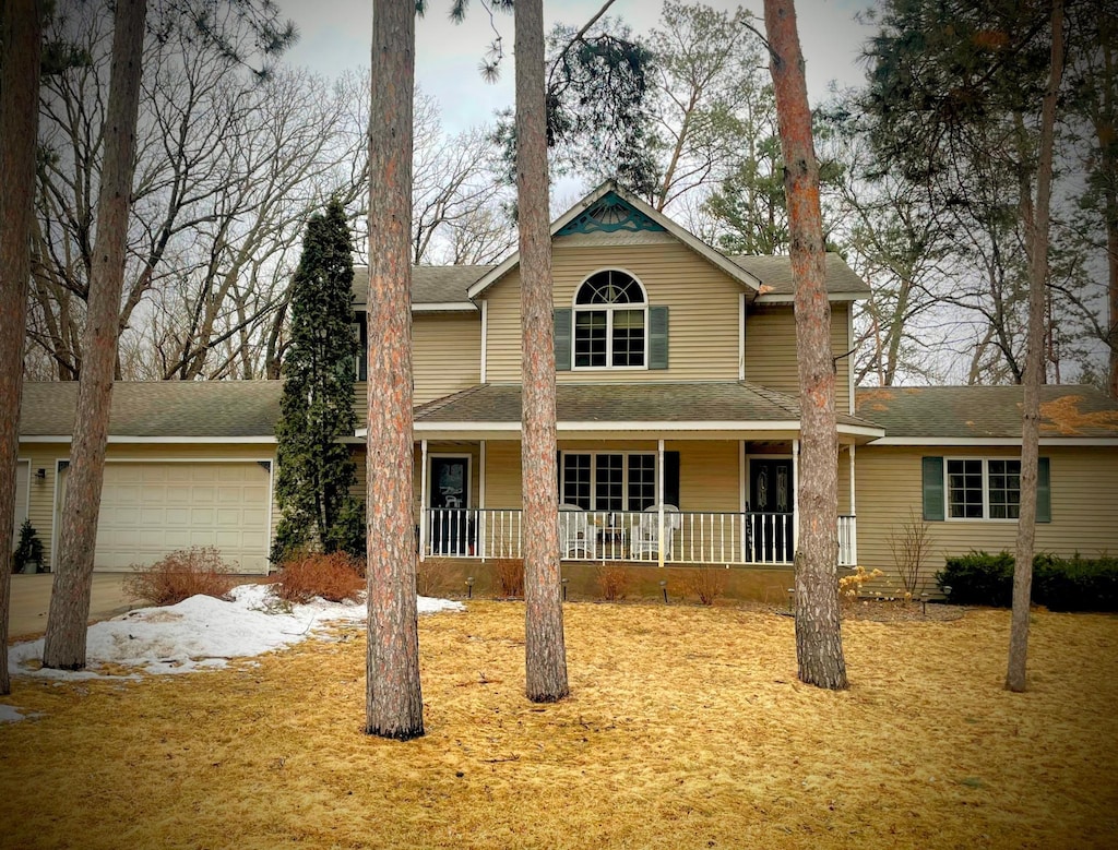 traditional home featuring covered porch and an attached garage