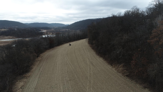 view of road featuring a wooded view and a mountain view