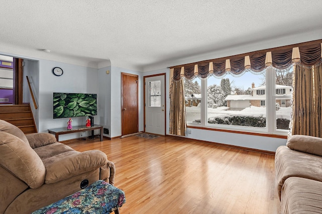 living area featuring plenty of natural light, a textured ceiling, and wood finished floors