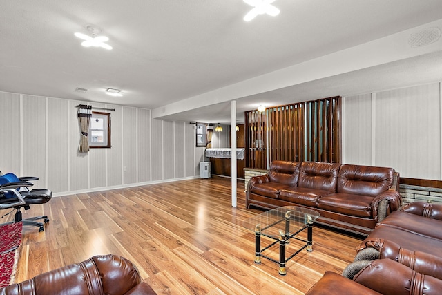 living room with wood finished floors, visible vents, and baseboards