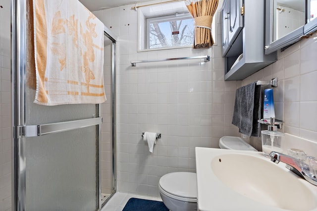 full bath featuring tile walls, tasteful backsplash, toilet, a stall shower, and a sink