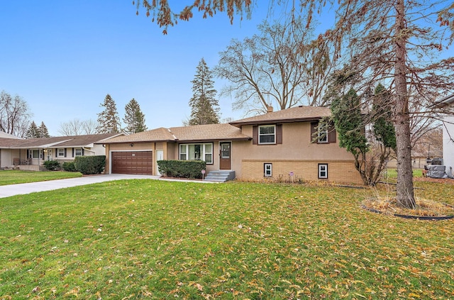 tri-level home with a garage, driveway, brick siding, and a front yard