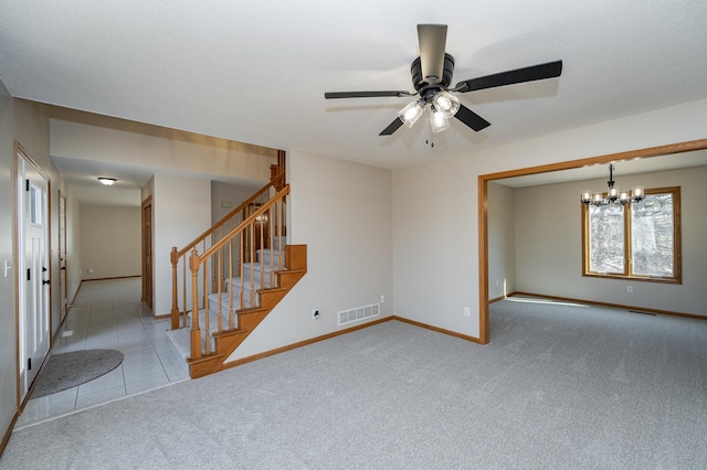 empty room with stairs, ceiling fan with notable chandelier, visible vents, and carpet floors