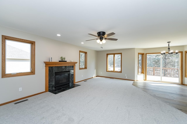 unfurnished living room with recessed lighting, visible vents, baseboards, and a high end fireplace