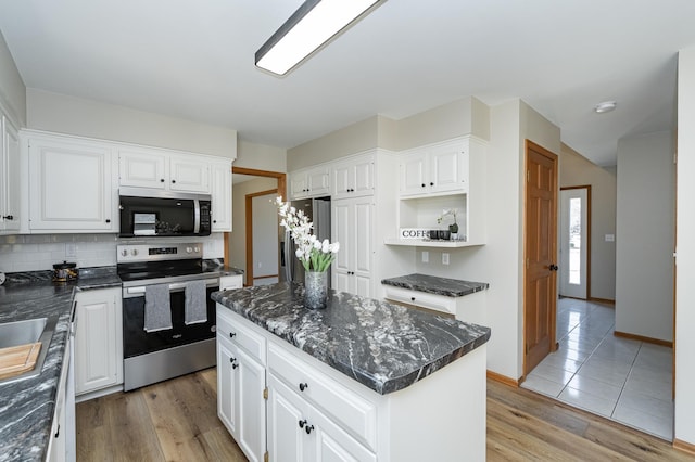 kitchen featuring a kitchen island, appliances with stainless steel finishes, white cabinetry, light wood-type flooring, and backsplash