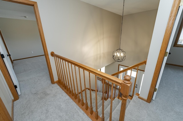 stairs with baseboards, carpet, a chandelier, and a towering ceiling