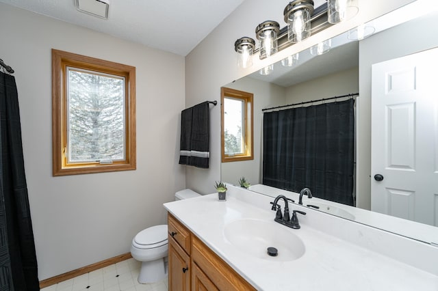 full bath featuring a healthy amount of sunlight, toilet, vanity, and baseboards