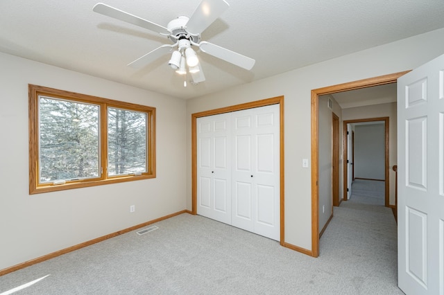 unfurnished bedroom with light carpet, visible vents, a closet, and baseboards