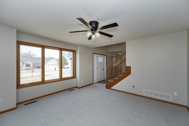 2511 Mayowood Ln SW, Rochester, MN 55902 - unfurnished living room featuring baseboards, carpet floors, stairway, and a ceiling fan