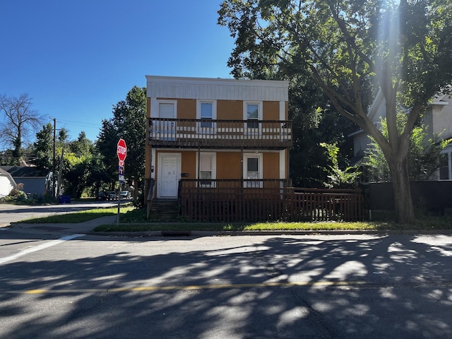 view of front facade with a fenced front yard and a balcony