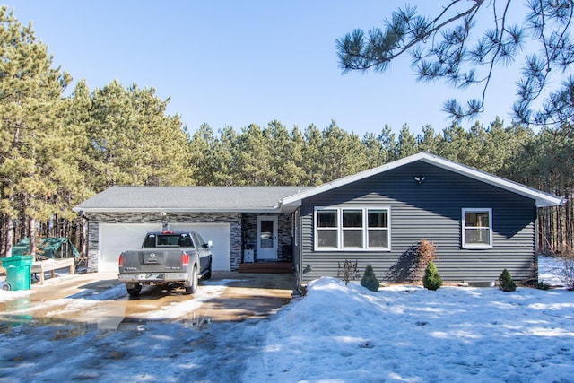 ranch-style home featuring stone siding, concrete driveway, and an attached garage