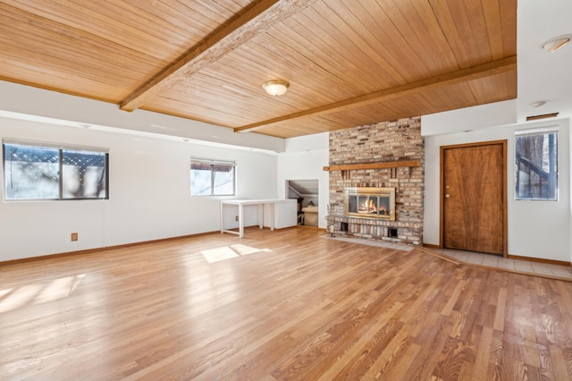 unfurnished living room featuring light wood finished floors, baseboards, wood ceiling, beamed ceiling, and a fireplace