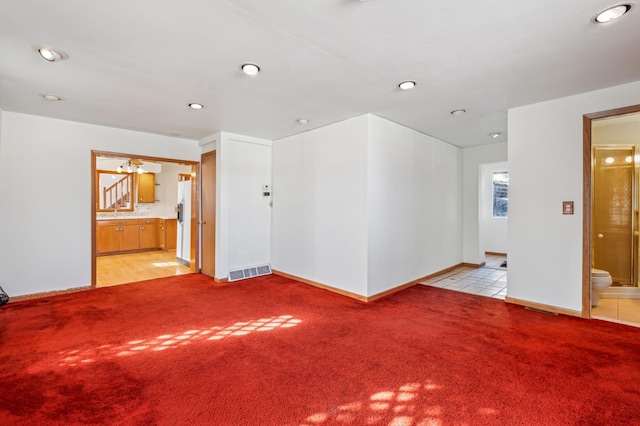 unfurnished room featuring light carpet, visible vents, and baseboards