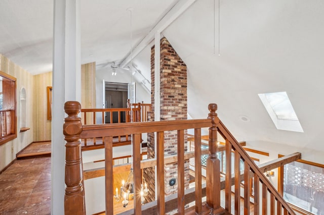 staircase featuring lofted ceiling with skylight and a ceiling fan